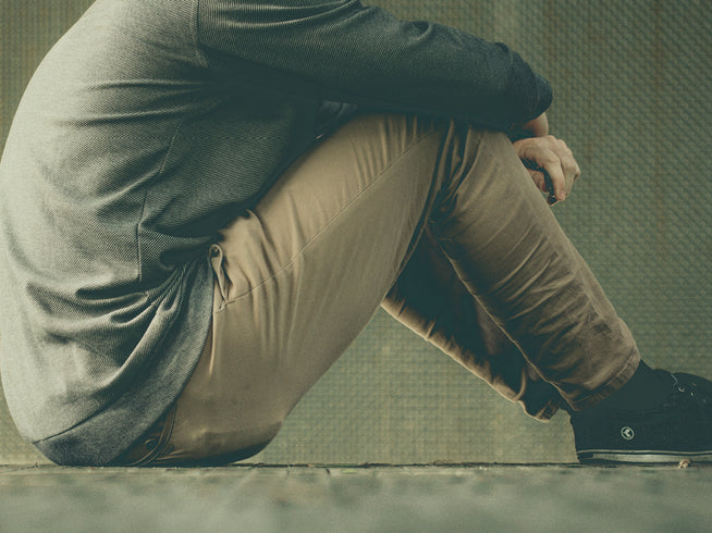 Photo of man sitting on ground in thought