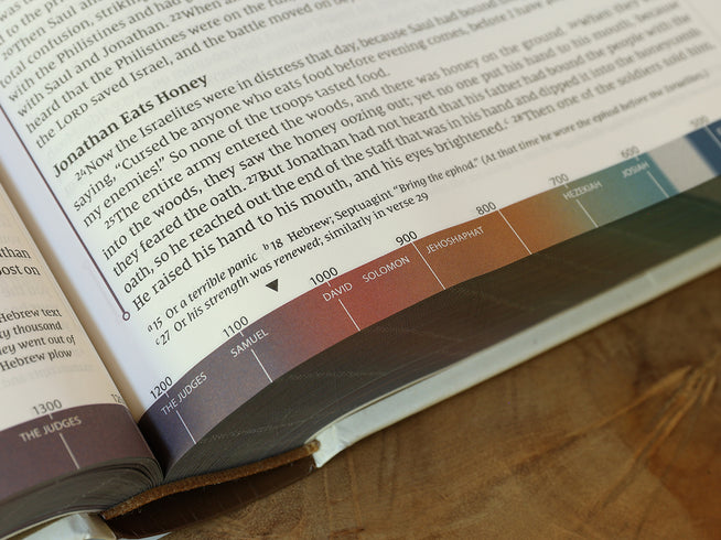 Open book with text and a color chart on a wooden surface