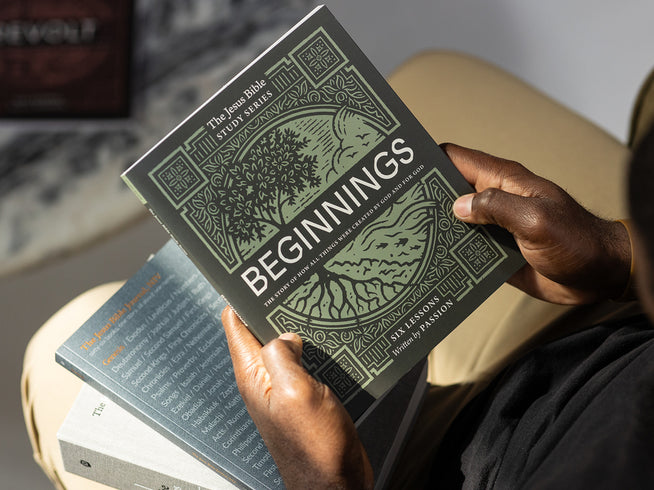 Person holding a book titled 'Beginnings' with decorative cover design.
