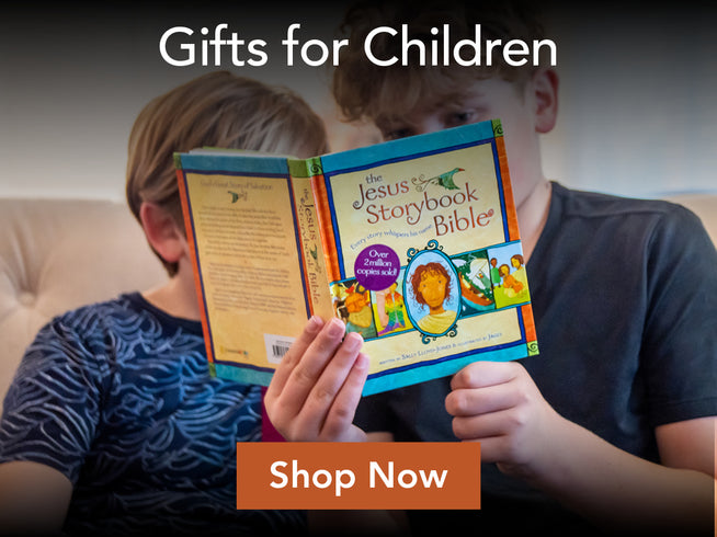 Two children sitting on a couch holding an open children's Bible titled 'The Jesus Storybook Bible.' Large text at the top reads 'Gifts for Children,' and an orange 'Shop Now' button appears at the bottom.