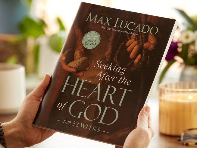 Seeking After the Heart of God by Max Lucado — book held up in a cozy setting