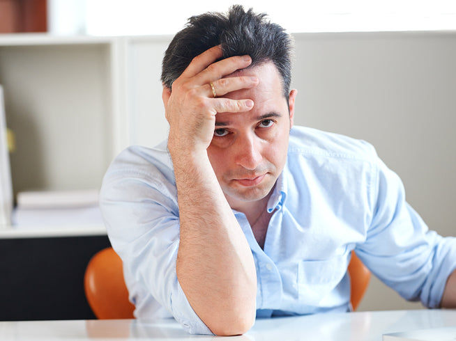Worried man with hand on forehead