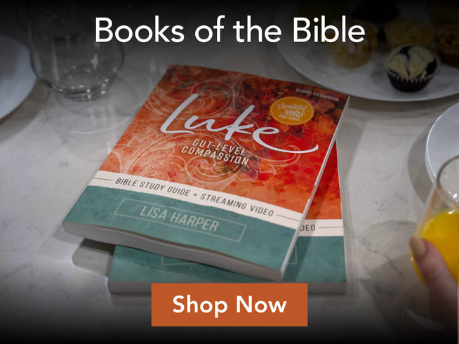 Book titled 'Luke' by Lisa Harper on a table with a glass of juice and a cupcake.