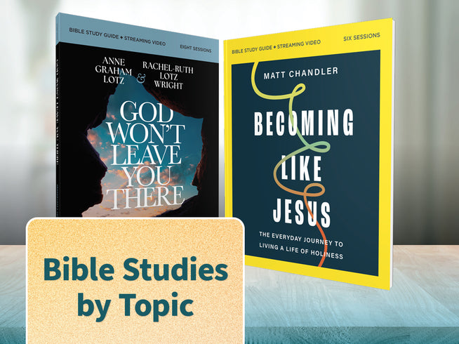 Two Bible study books are shown standing upright on a tabletop against a blurred indoor background. The left book is titled 'God Won't Leave You There' with a black cover and blue-toned artwork.