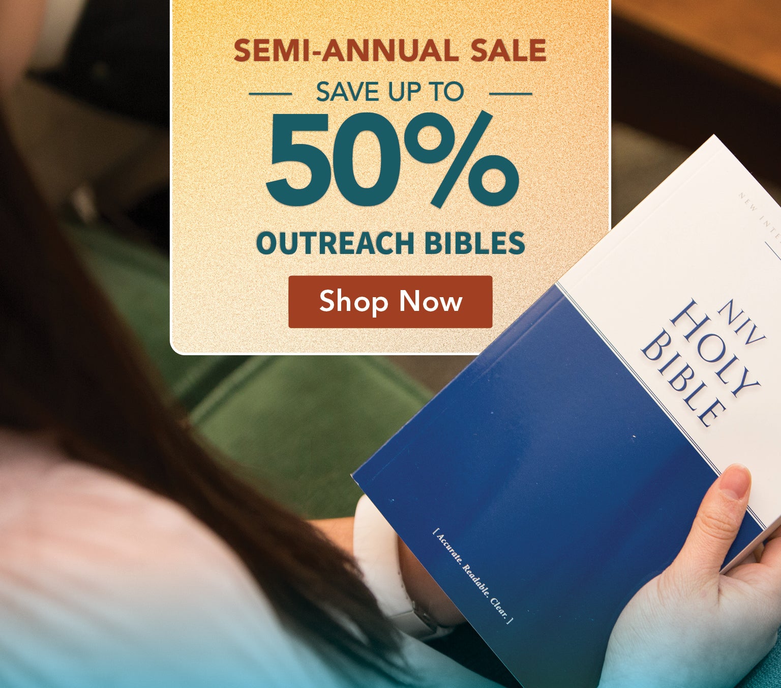 A person holds a blue and white 'New Holy Bible' in a real indoor setting, with a large sale overlay reading 'Semi-Annual Sale Save Up to 50% Outreach Bibles' and a 'Shop Now' button.